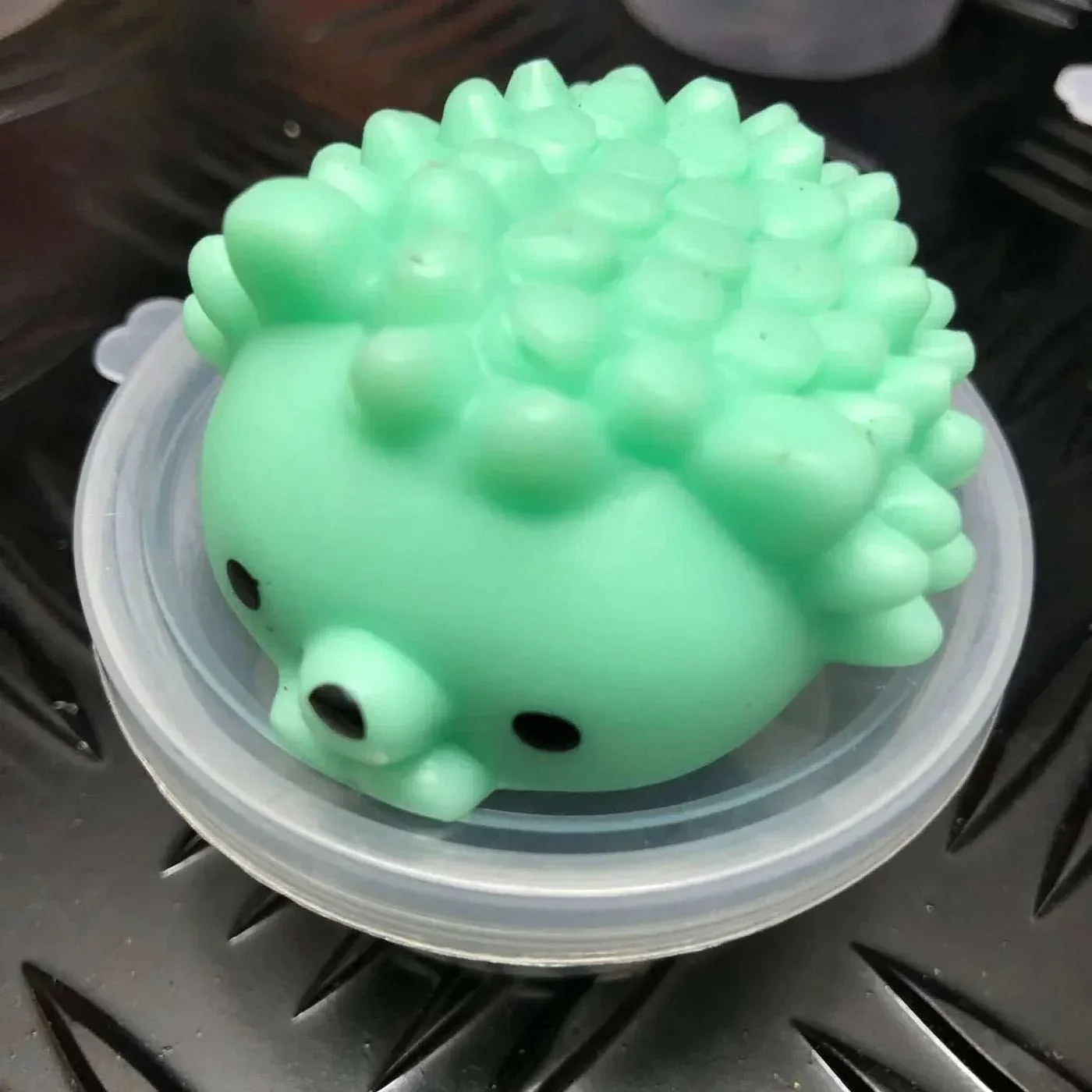 Mint green Jelly Mochi Squishy Animal shaped like a spiky hedgehog on a plastic lid