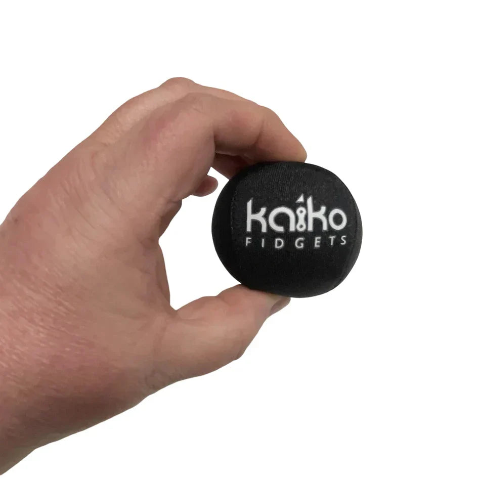 Hand holding black Kaiko Fidgets extreme squishy ball from Losing Your Sh!t fidget kit for stress relief and hand exercise